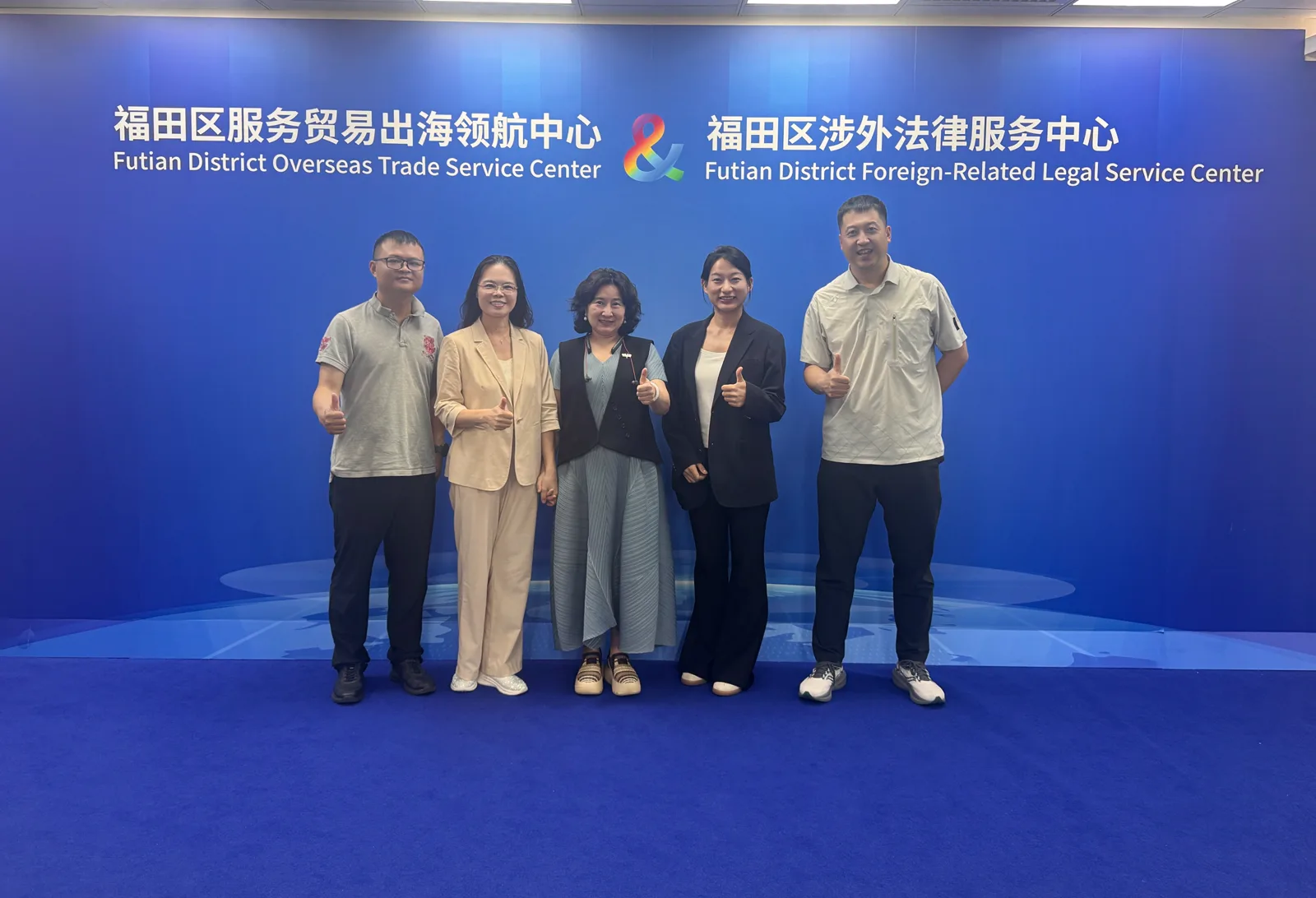 五人在福田区服务贸易出海领航中心背景墙前合影,画面中没有康康