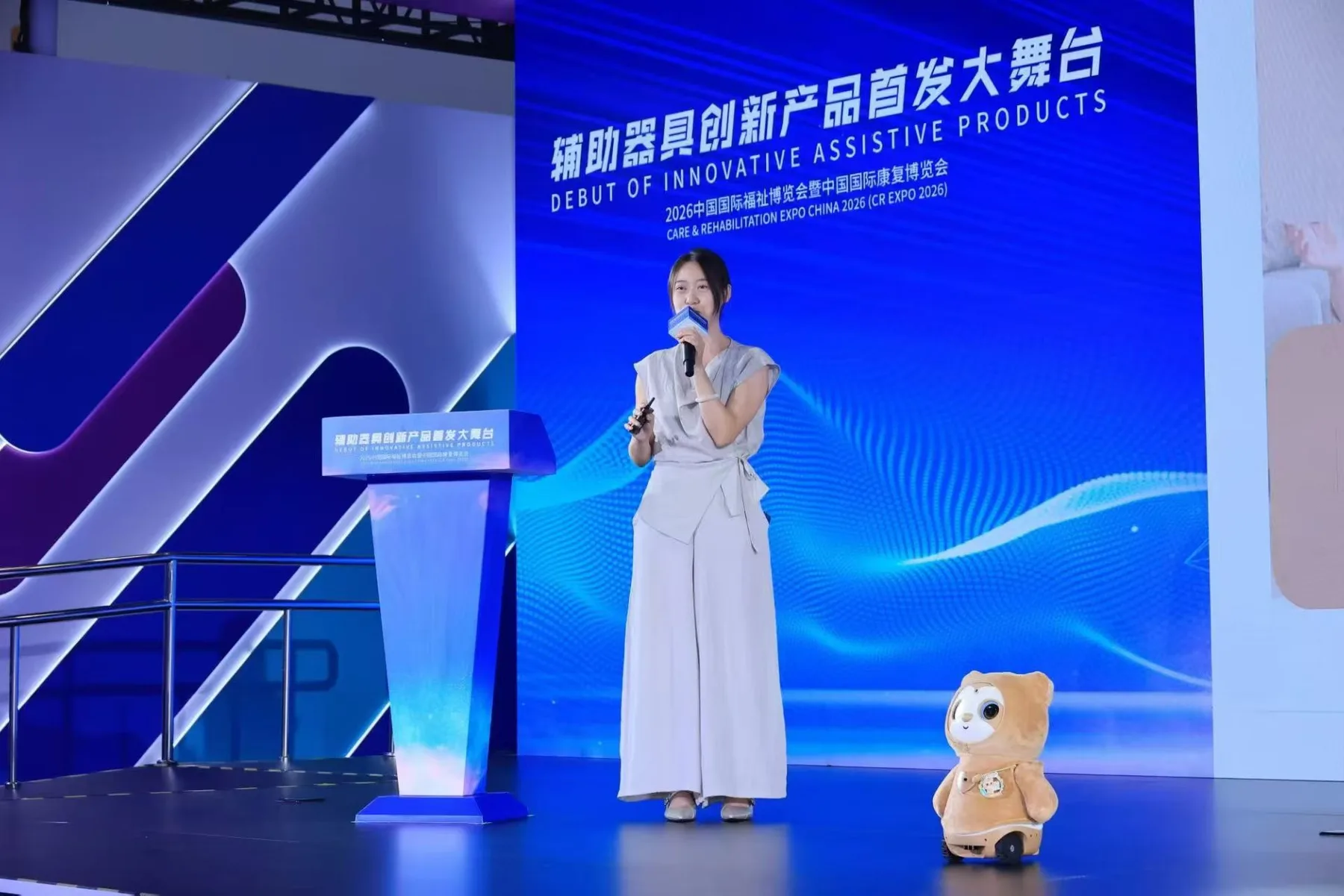 展会舞台上有人发言,康康在一旁展示