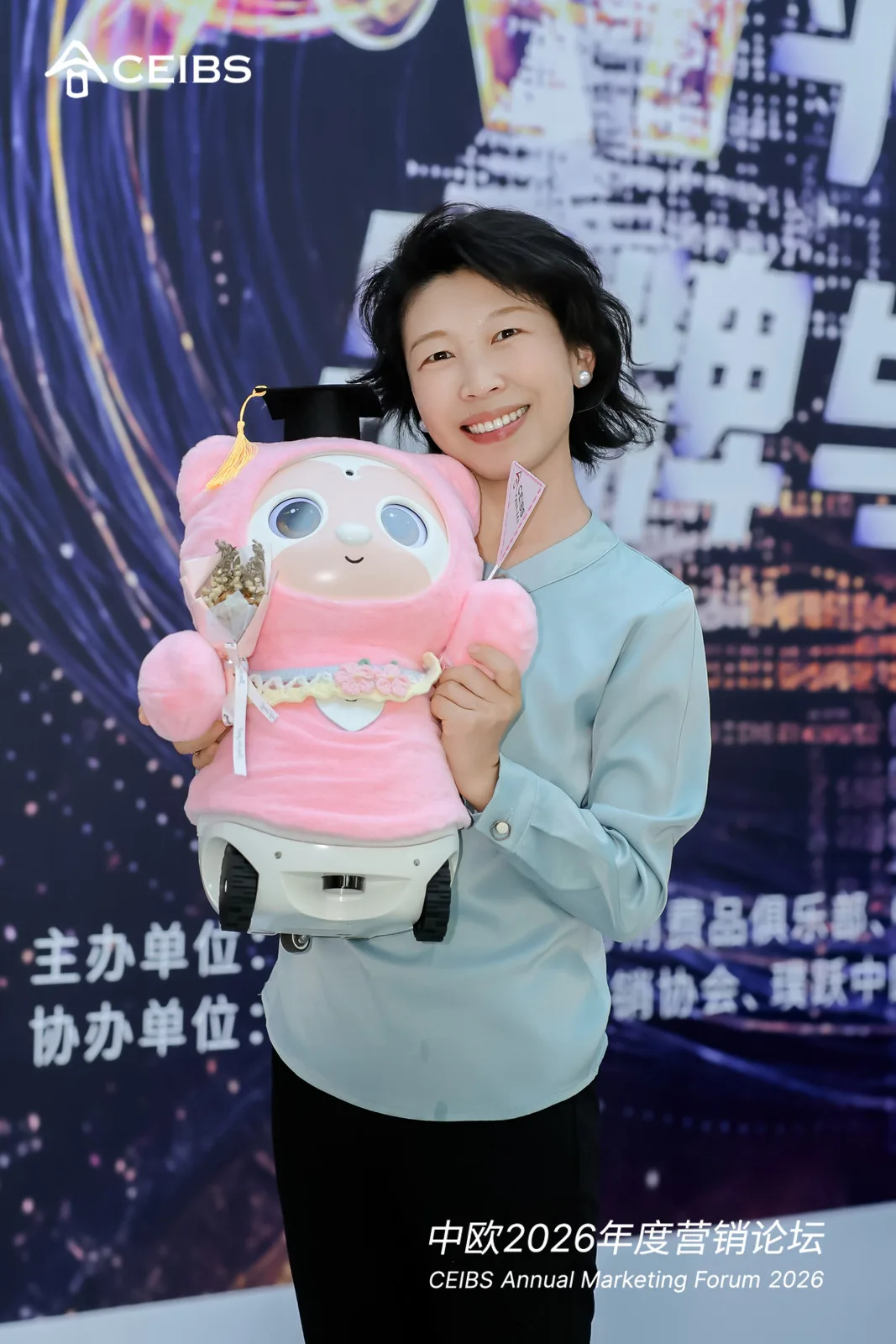 来宾在中欧营销论坛现场抱着粉色康康合影